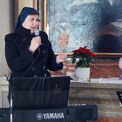 Sr. Maria bittet die versammelte Gottesdienstgemeinde für ein Erstkommunionkind zu beten, und dazu eine vom Kind gebastelte Blume mitzunehmen.